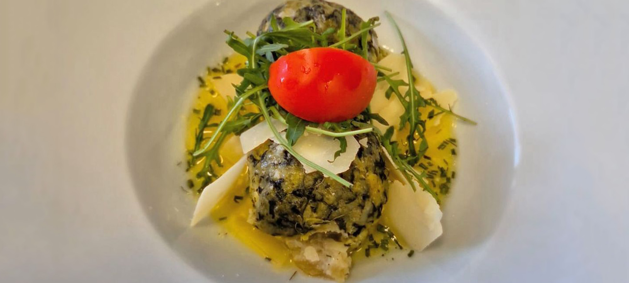 Spinatknödel mit Käse und Tomate in der Liftstube